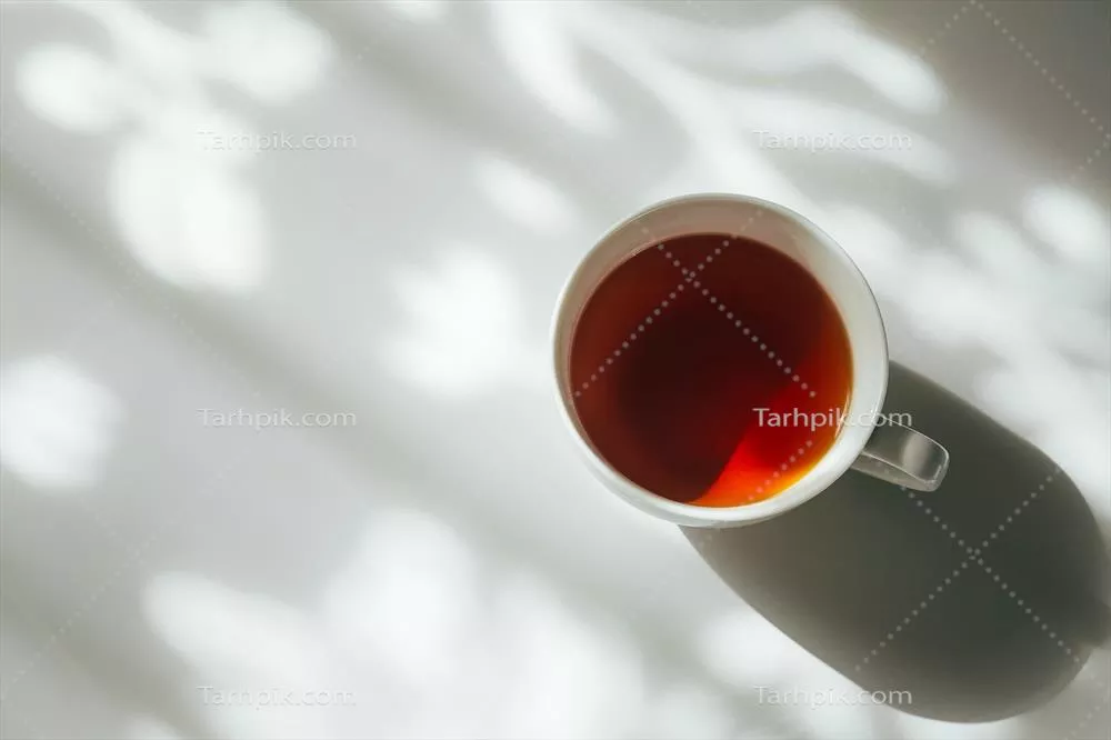 فنجان سفیدی از چای بر روی پس زمینه انتزاعی سایه پرده طبیعی بر روی میز سفید
