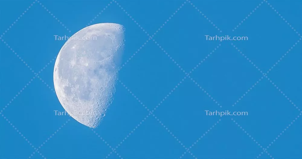 عکس نمای نزدیک از ماه نیمه، در طول روز در آسمان آبی