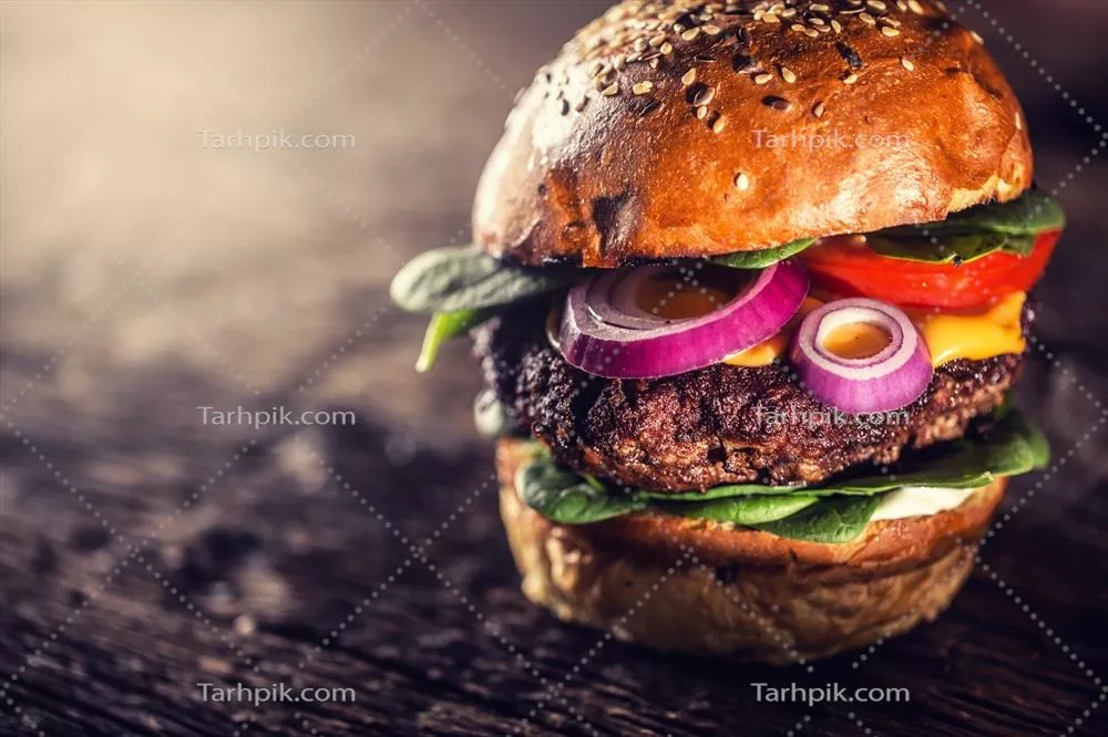 برگر گوشت گاو لذیذ با سالاد اسفناج، پیاز، گوجه فرنگی و پنیر