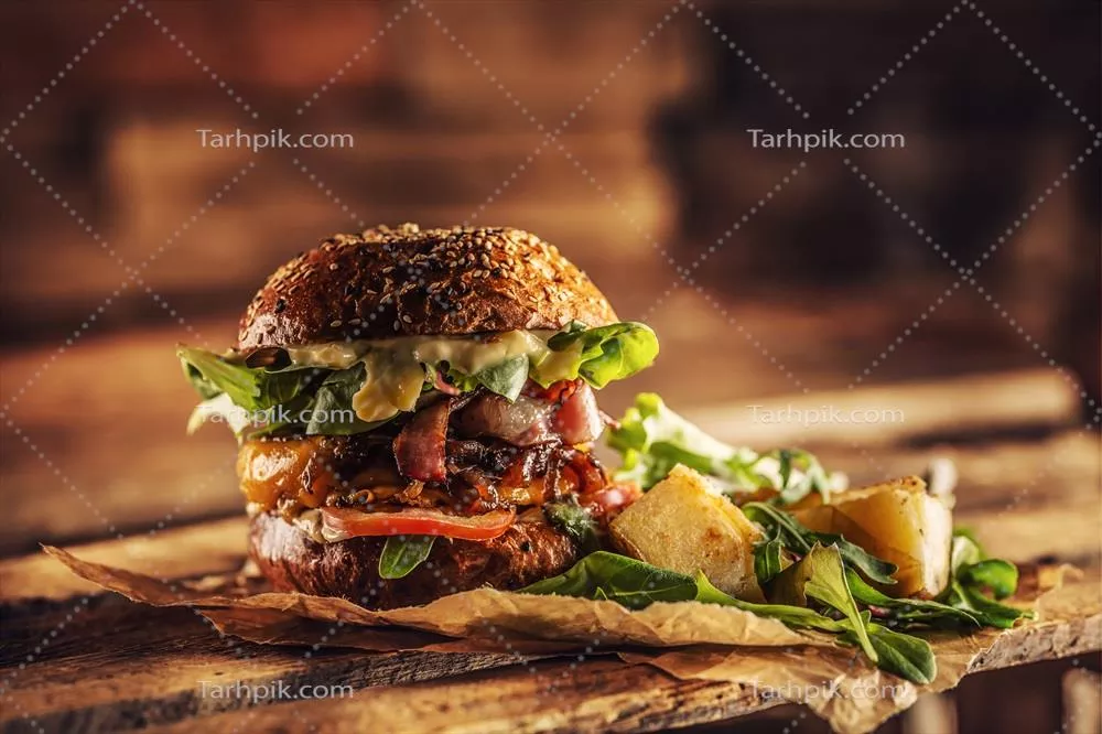 برگر خانگی خوشمزه با بیکن، پیاز، پنیر و کاهو در جعبه چوبی