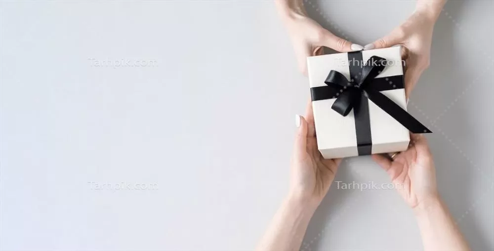 جعبه هدیه سفارشی به رنگ سفید با دستانی بر روی پس‌زمینه قرمز و فضای خالی