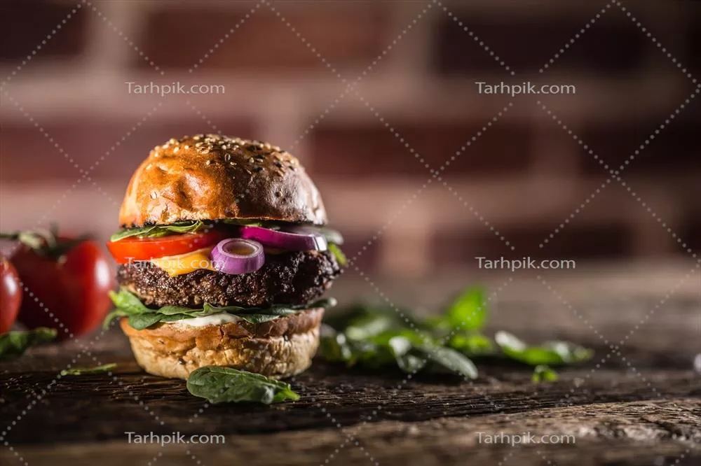 برگر گوشت گوساله خوشمزه با سالاد اسفناج، پیاز، گوجه‌فرنگی و پنیر