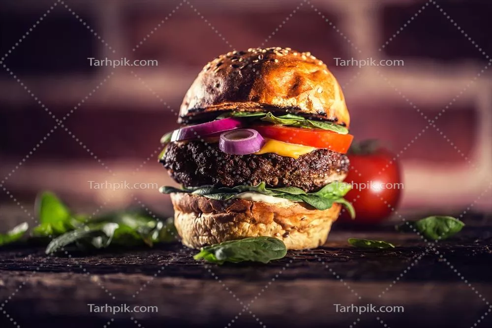 برگر خوشمزه گوشت گاو با سالاد اسفناج، پیاز، گوجهفرنگی و پنیر