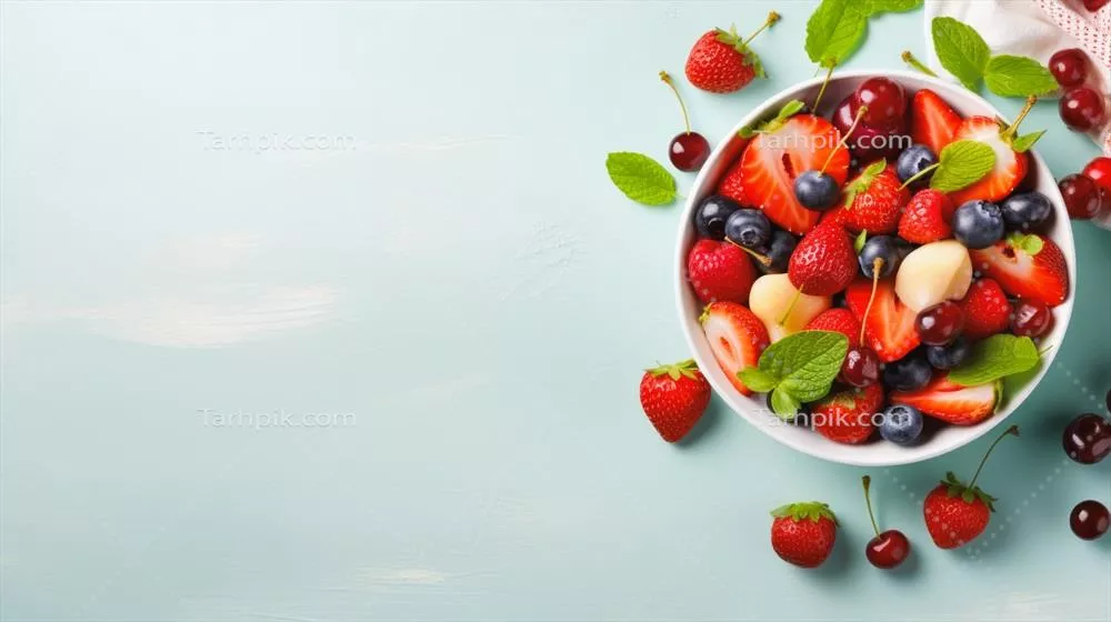 سالاد میوهای خوشمزه با توتفرنگی، توتزرینی و گیلاس در بشقاب روی پسزمینه چوبی آبی
