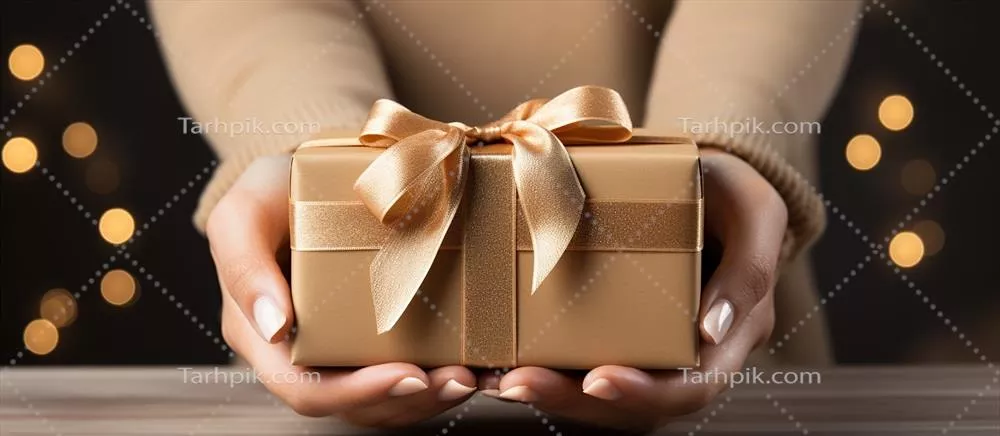 تصویری زیبا از یک جعبه هدیه در دستان با پسزمینه کریسمس