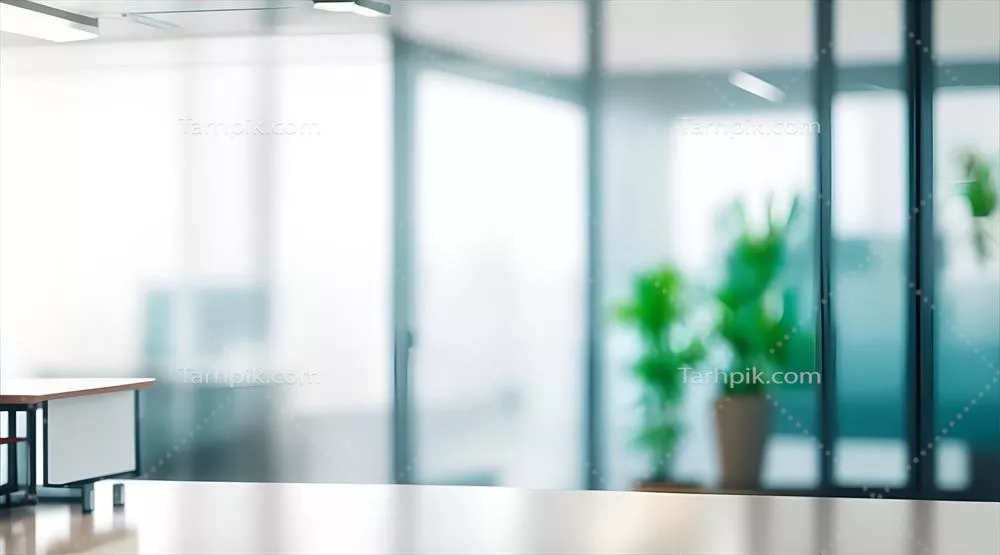 فضای اداری مدرن با نور مناسب، تقسیمات شیشهای و گیاهان سبز در پسزمینه محو