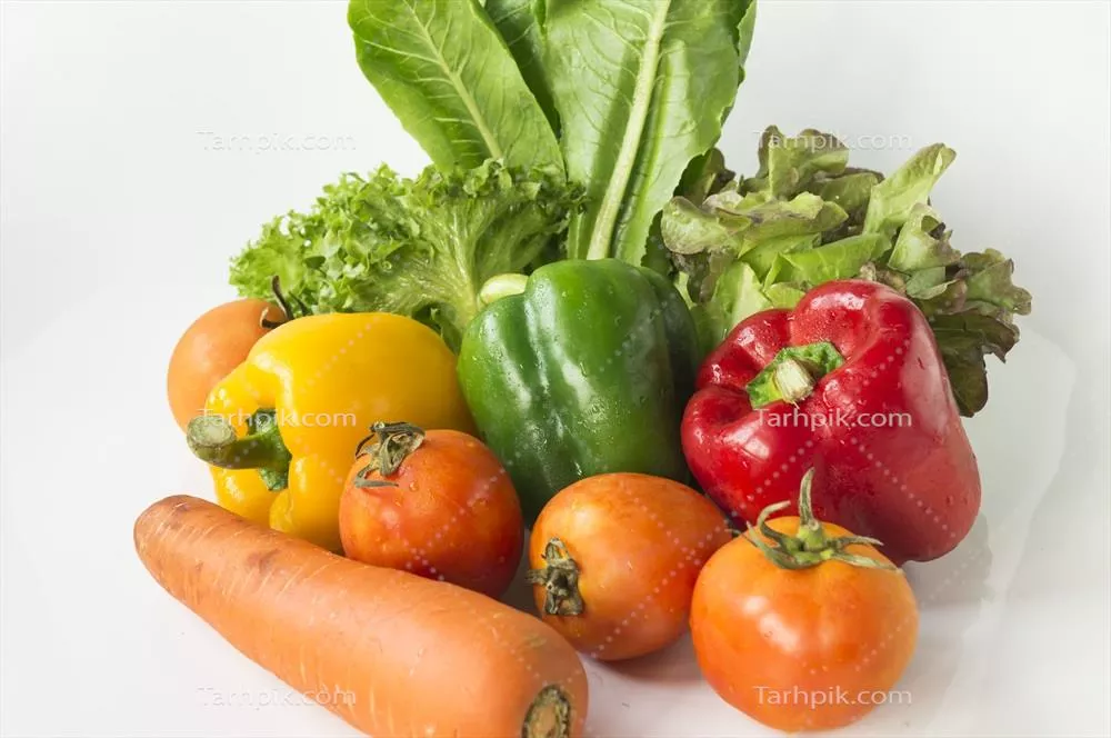 یک دسته از سبزیجات رنگارنگ بر روی یک سطح سفید