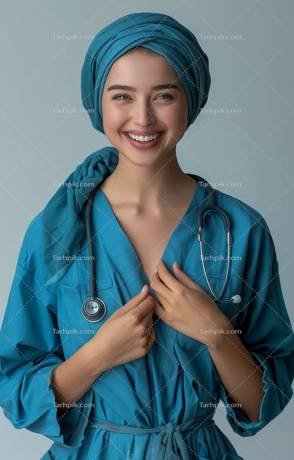 پرستار جوان در لباس آبی با شال و گوشی پزشکی در حال خندیدن و لمس قلبش در پس زمینه سفید