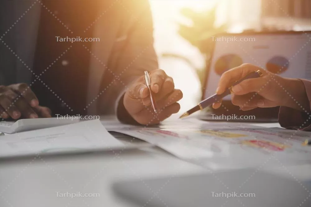تحلیل نزدیک از تیم تجاری در حال بررسی نمودارهای درآمد با لپ‌تاپ مدرن و استراتژی کسب‌وکار