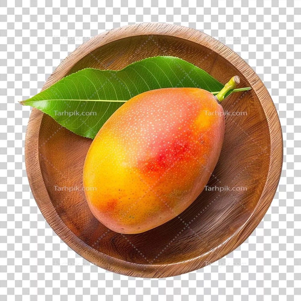 مغز شیرین و رسیده انبه در یک کاسه چوبی با برگ سبز