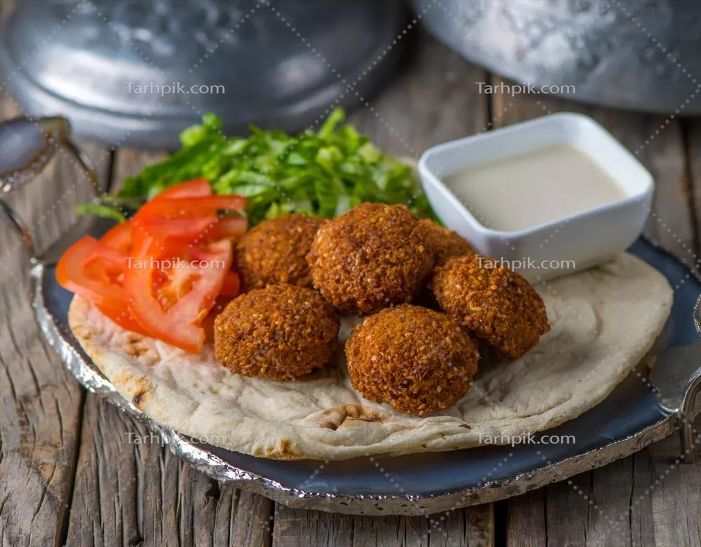 فلافل با رایتا، سرو شده در ظرف درنما از نمای جانبی بر روی میز چوبی