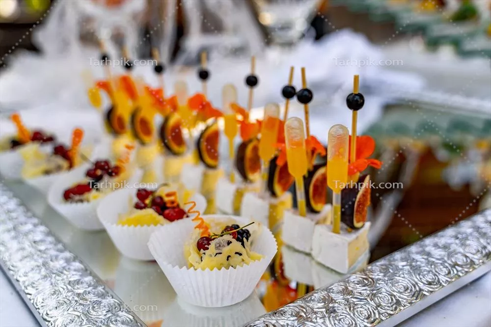 تنوعی از پیش غذاهای سرد و شیرین بر روی میز بوفه برای مراسم جشن و مهمانی