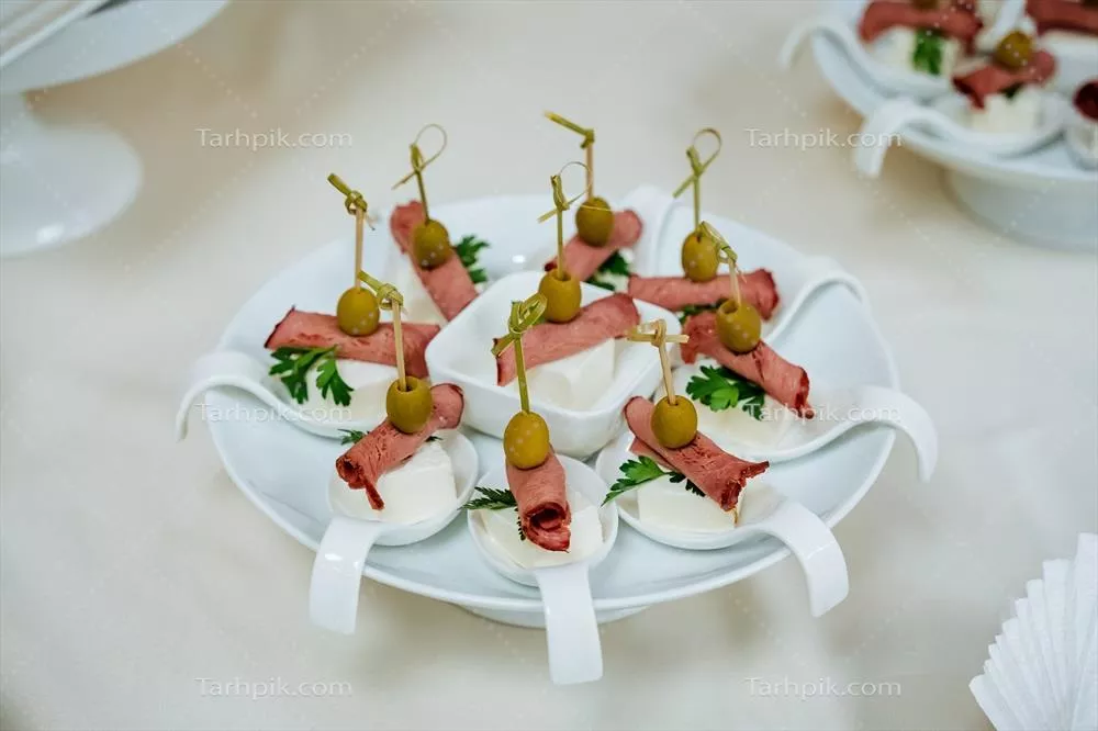 تزئین بشقاب پیش غذا با سیخ گوشت و پنیر و زیتون برای مراسمات