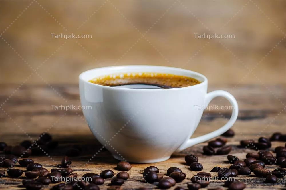 عکس یک فنجان قهوه همراه با دانه قهوه در پسزمینه چوبی