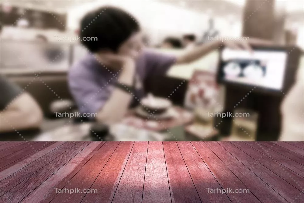 عکس تصویر نزدیک از یک میز چوبی با پس زمینه رستوران مات