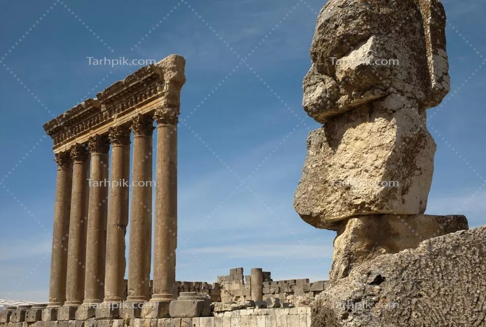 عکس نمایی از معبد بعلبک و ستونهای تاریخی با مجسمه سنگی