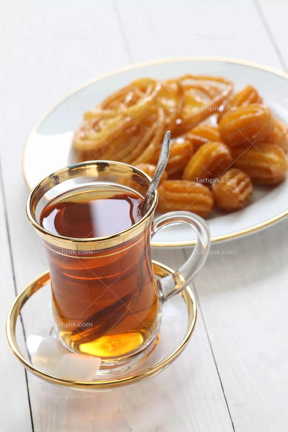 عکس لذت نوشیدن چای همراه با شیرینی بامیه خوشمزه