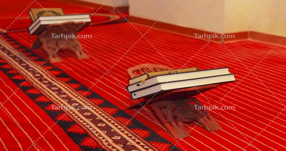 عکس قرار گرفتن قرآن و کتاب دعا بر روی رحل در مسجد با فرش قرمز