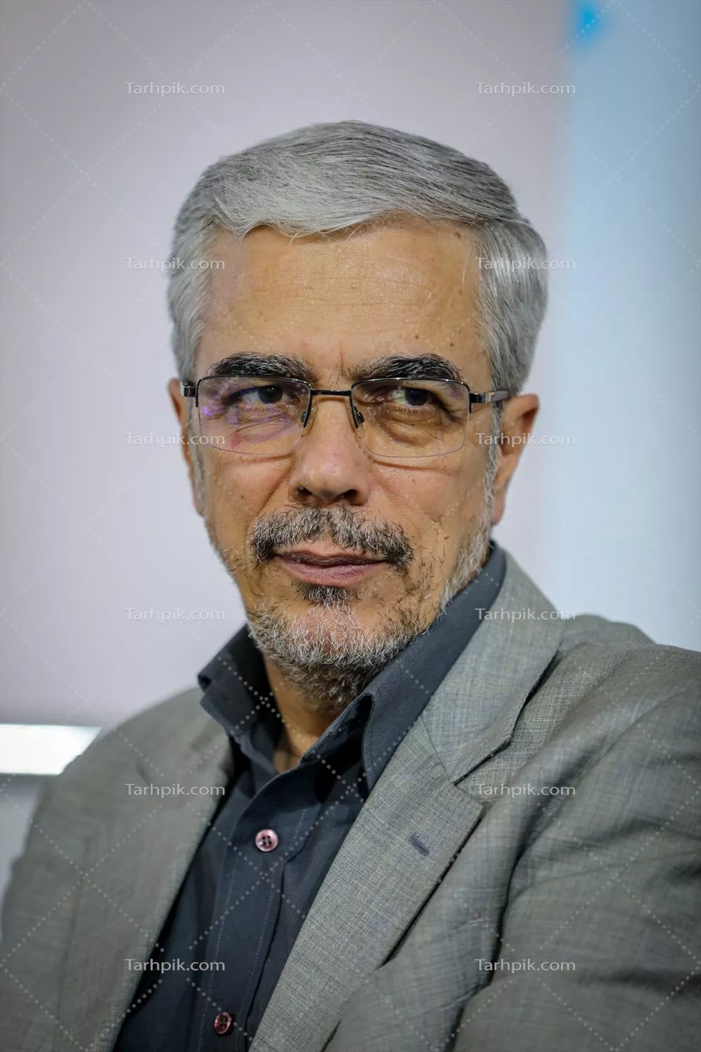 عکس تصویری از مردی در لباس رسمی با عینک و موی خاکستری