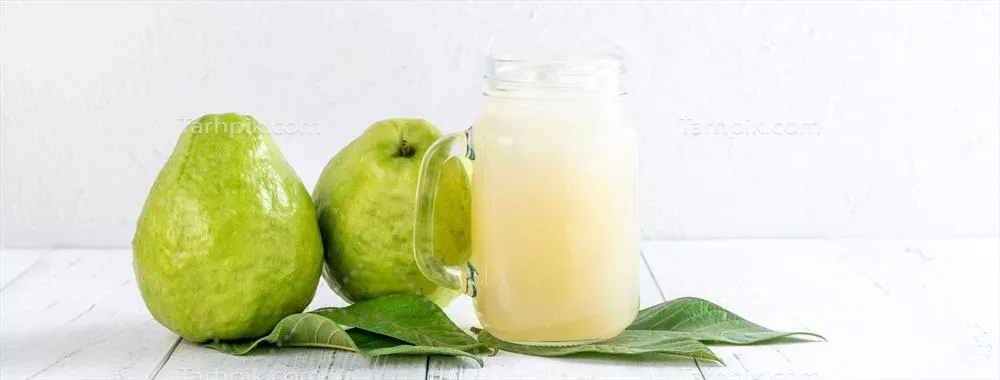 عکس میوه گواوا خوشمزه با شربت تازه در پسزمینه جدول چوبی سفید