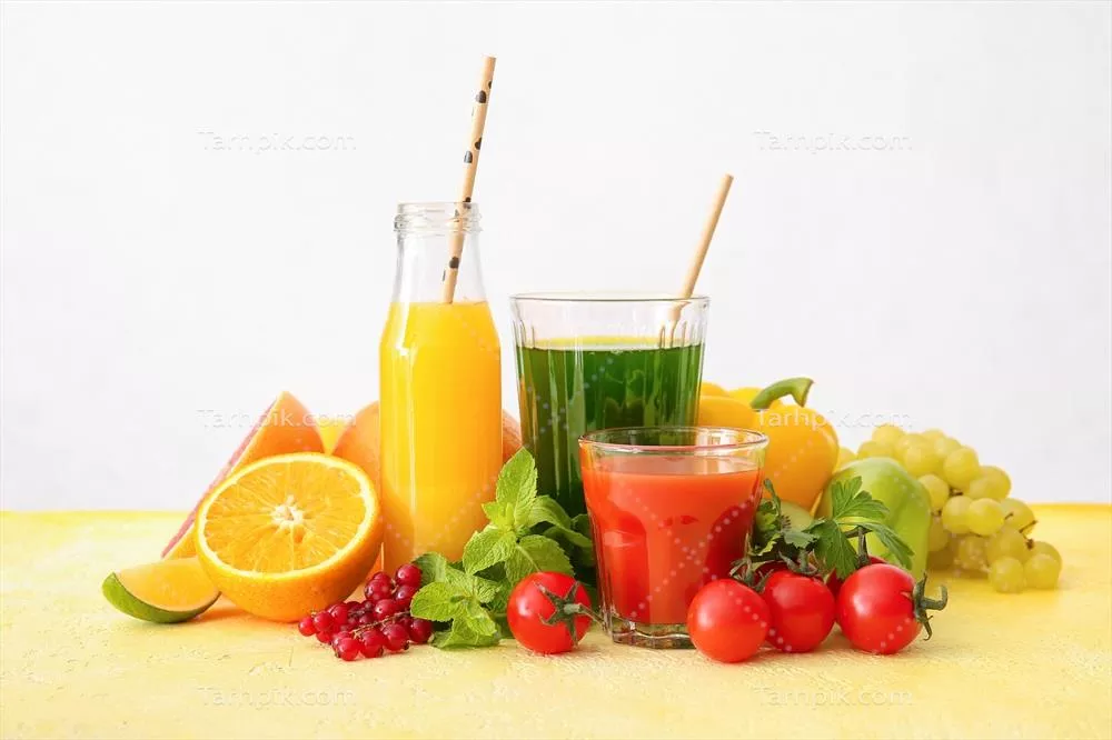 عکس لیوان‌های حاوی آبمیوه سالم از میوه‌ها و سبزیجات در زمینه روشن