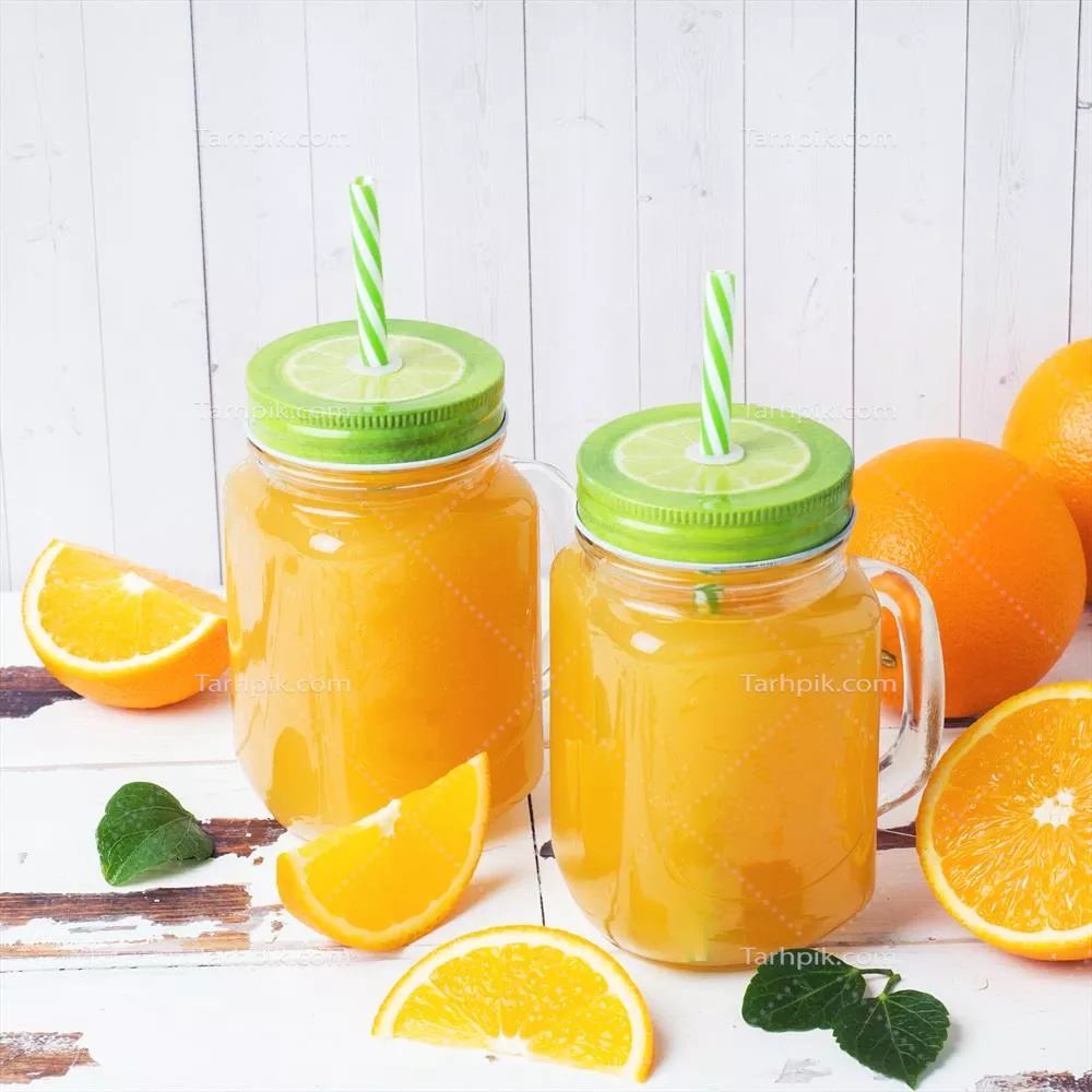 عکس عصاره پرتقال در شیشه های شفاف و میوه های تازه پرتقال در پس زمینه چوبی روستیک