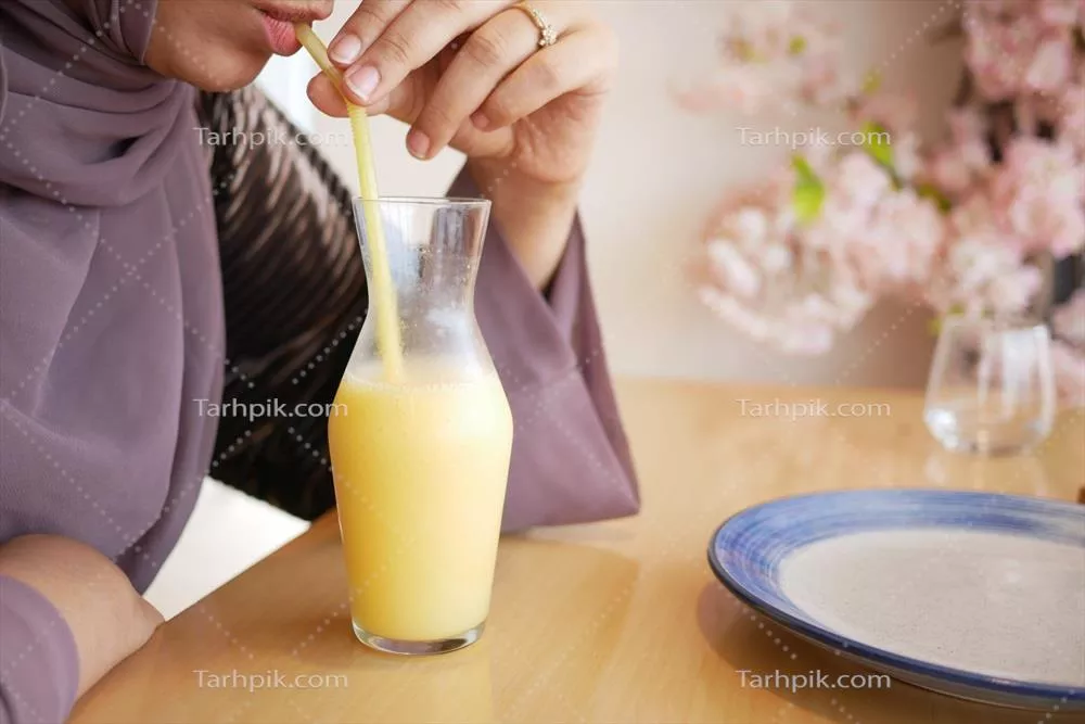 عکس زنان در حال نوشیدن آبمیوه آناناس از بطری در کنار میز