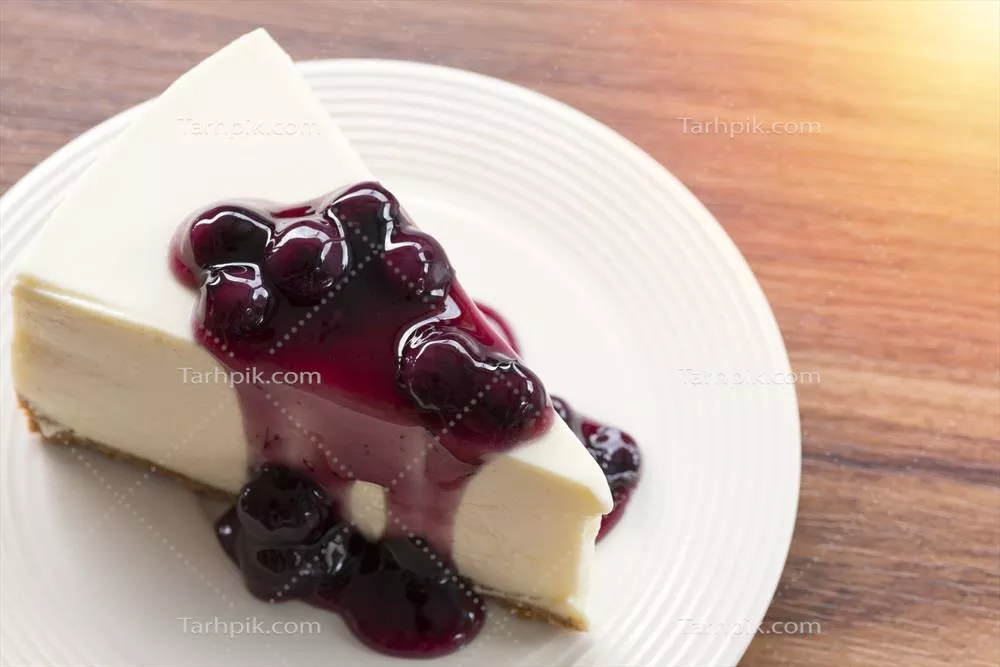 عکس پنکیک پنیر خامه ای با توت آمریکایی بر روی بشقاب سفید در یک میز چوبی