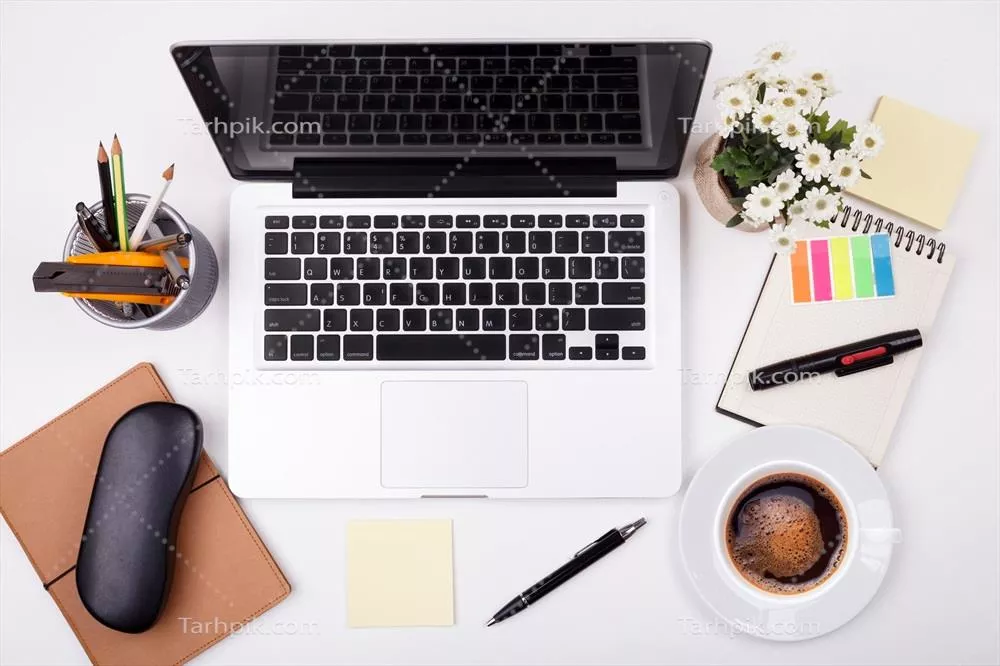 عکس فضای کاری مدرن با لپتاپ یا نوتبوک در یک میز سفید، نمای بالا