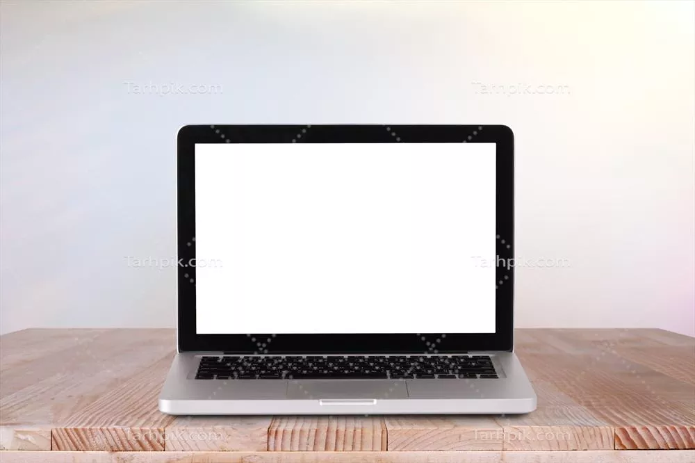 عکس نمای جلویی لپ‌تاپ روی میز کار با پس‌زمینه سبز محو