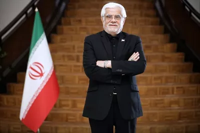 عکس محمدرضا عارف ایستاده کنار پرچم ایران با کیفیت بالا