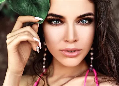 عکس پرتره‌ای از زن زیبا با موهای بلند تیره و لباس صورتی