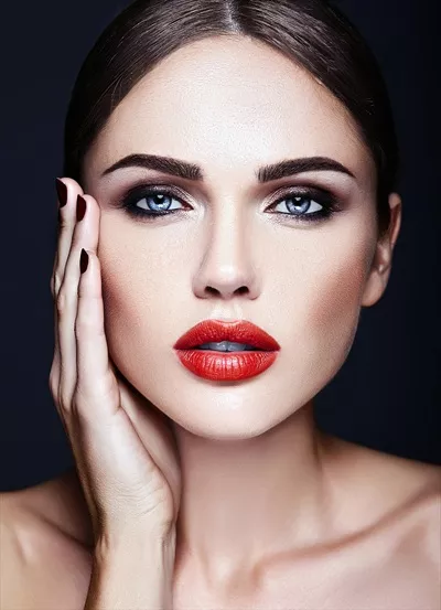 عکس پرتره‌ای از زن زیبا با لب‌های قرمز و پوست سالم و تمیز