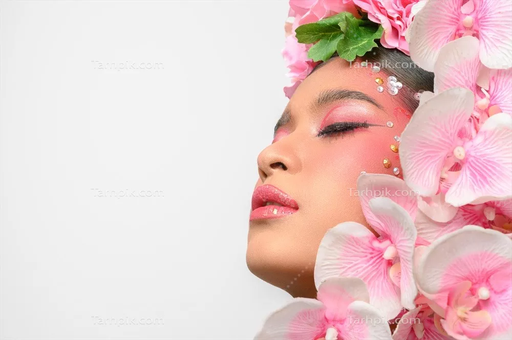 عکس زن با آرایش صورتی و گل های زیبا بر روی پس زمینه سفید