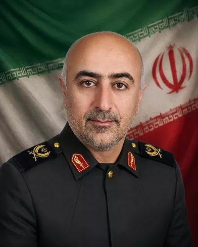 عکس شهید علی رستمی با پرچم ایران در تصویر