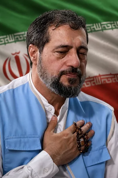 عکس شهید علیرضا بیات با پرچم ایران در پس زمینه
