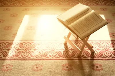عکس قرآن با نوری که از پنجره تابیده است