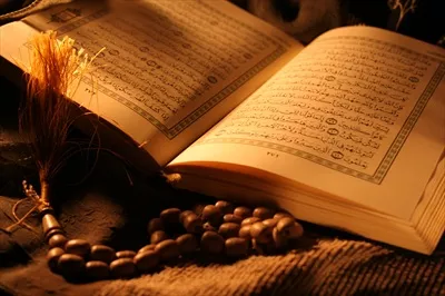 عکس قرآن باز و تسبیح در کنار آن