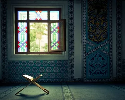 عکس قرآن در مسجد با پنجره باز و نور طبیعی در حال تابش