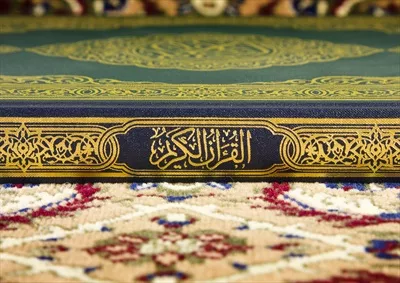 عکس قرآن کریم روی فرش مسجد با طراحی سنتی و زیبا