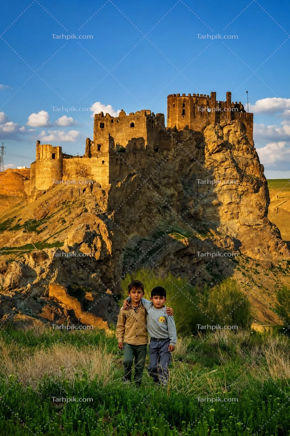 عکس کودکان با پسزمینه قلعه الموت در یک روز خوش آب و هوا