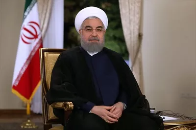 عکس دکتر روحانی نشسته کنار پرچم ایران و نماد ملیت و هویت